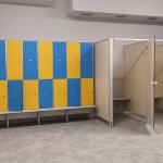 szatnia z wyposażeniem żółto-niebieskich szafek na ubrania oraz kabin przebieralni
