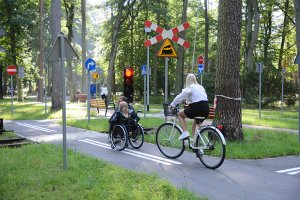 Osoby na wózkach inwalidzkich i na rowerze korzystają z miasteczka ruchu drogowego w SOSW nr 1 w Policach