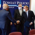 Przedstawiciele Powiatu Polickiego i Grupy Azoty Polyolefins S.A. stoją i przekazują sobie porozumienie