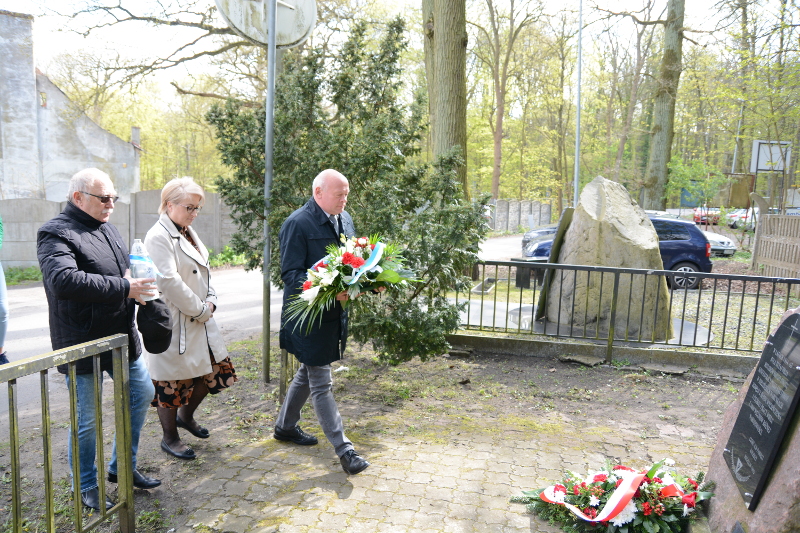 Przedstawiciele władz samorzadowych składają kwiaty przed pomnikiem