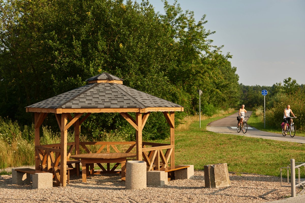 Drewniana altana piknikowa na trasie szlaku turystycznego dla rowerów.