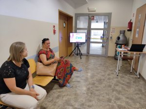 Korytarz i dwie osoby siedzące po lewej stronie