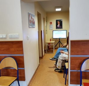 Korytarz prowadzący do gabinetu lekarskiego, w tle monitor