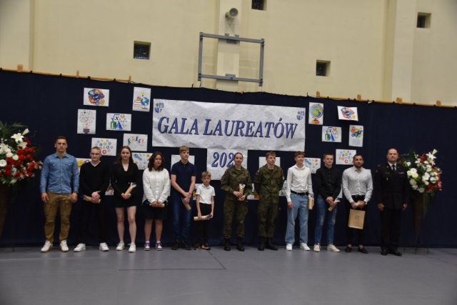 Nagrodzeni uczestnicy Gali Laureatów wraz z otrzymanymi prezentami pozują do zdjęcia.