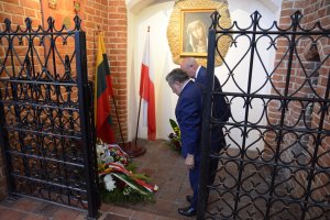 Przewodniczący Rady Powiatu w Policach i Burmistrz Polic składają kwiaty pod tablicą