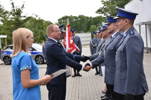 Moment wręczenia awansów dla funkcjonariuszy Komendy Powiatowej Policji w Policach podczas uroczystego apelu odbywające się na placu przed komendą.