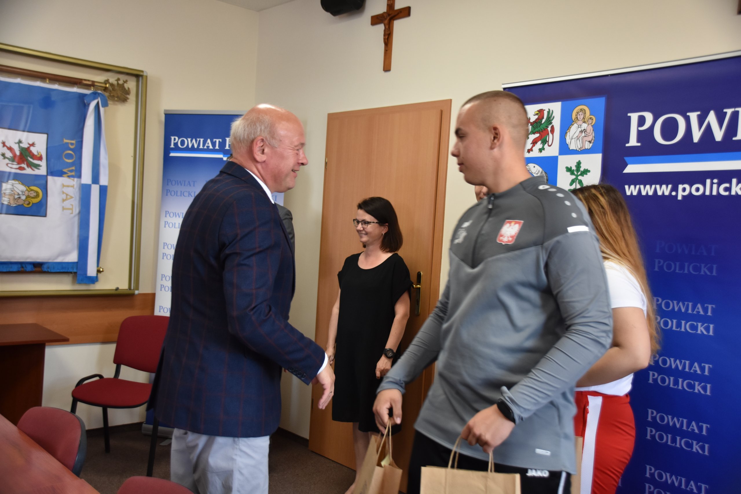 Moment gratulacji składanych przez Przewodniczacego Rady Powiatu w Policach drugiemu trenerowi Szymonowi Pełce.