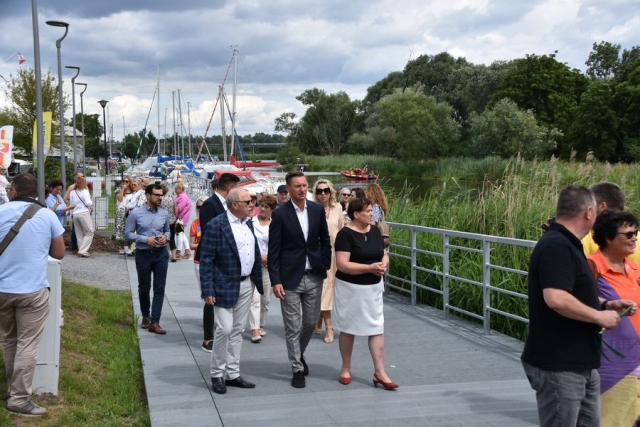 Zaproszeni goście, spacerujący po pomoście wzdłuż rzeki Łarpia