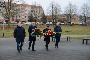 Przedstawiciele samorządu powiatowego i gminnego idą z kwiatami