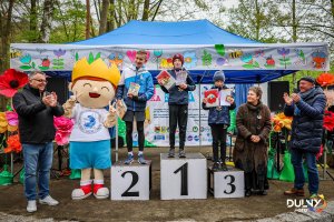 Zawodnicy i wręczający stoją na podium z nagrodami