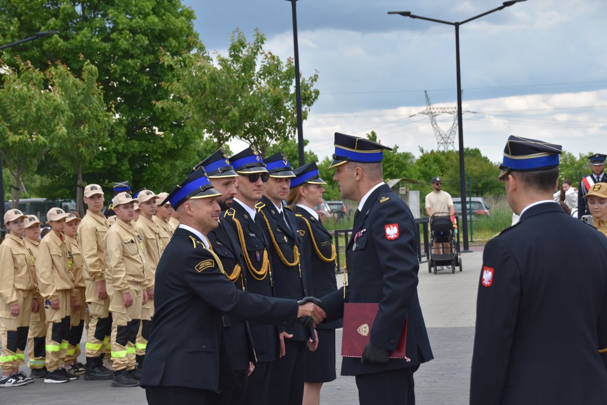 Grupa ludzi w mundurach galowych stojąca w szeregu podczas ceremoni wręczania awansów.