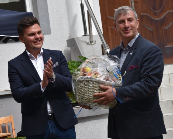 Przedstawiciele Powiatu Polickiego stoją z koszem pełnym jabłek dla uczestników wydarzenia.
