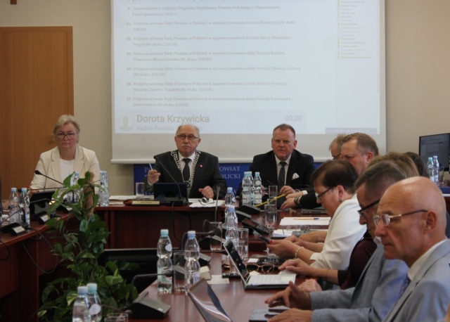 Przewodniczący Rady Powiatu w Policach słucha wypowiedzi Radnej.