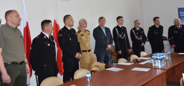 Strażacy wraz z Członkiem Zarządu Powiatu Polickiego poczas przemawiania do uczestników konkursu.