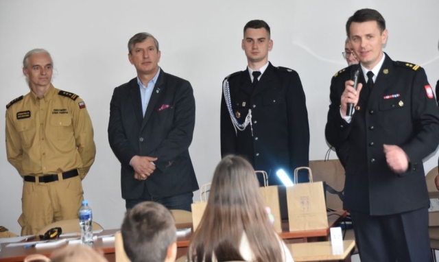 Strażacy wraz z Członkiem Zarządu Powiatu Polickiego poczas przemawiania do uczestników konkursu.