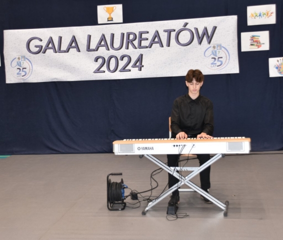 Uczeń występuje grając na klawiszach podczas Powiatowej Gali Laureatów 2024