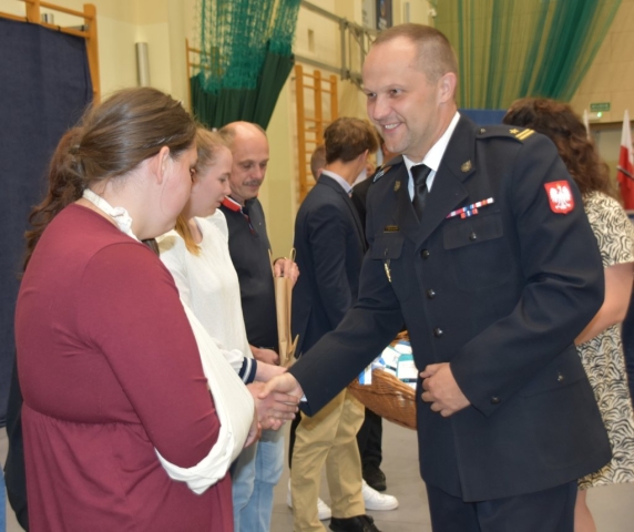 Komendant Powiatowej Państwowej Straży Pożarnej w Policach Piotr Maciejczyk składa gratulacje nagrodzonym uczniom