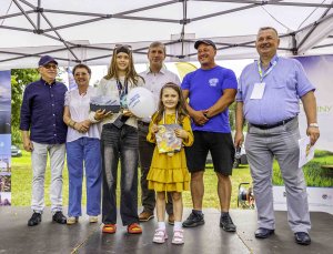 grupa ludzi pozująca na scenie podczas wydarzenia do zdjęcia.Wśró nich przedstawiciele samorządó będących partnerami przedsięwzięcia oraz Burmistrz Nowego Warpna i laureatki jednego z konkursów odbywających się wtrakcie wydarzenia.