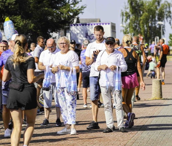 Przedstawiciele Powiatu Polickiego wręczają medale dla uczestników, którzy ukończyli bieg.