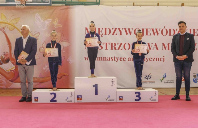 Gimnastyczki na podium z dyplomami wraz z zaproszonymi gośćmi