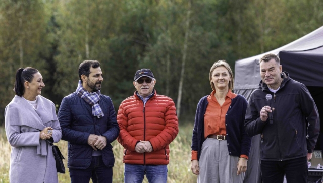 Grupowe zdjęcie uczestników wydarzenia, w tym trzech mężczyzn i dwie kobiety, którzy pozują razem w radosnej atmosferze.