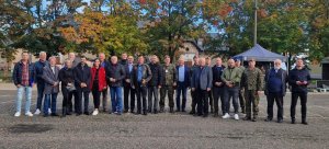 Grupa ludzi, mężczyźni, kobiety pozujący na pacu do zdjęcia grupowego.