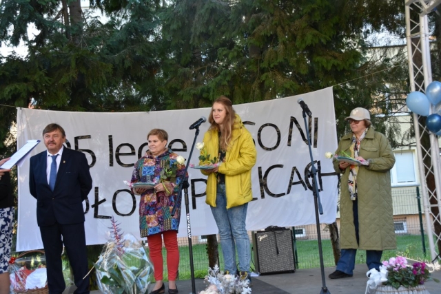 Goście na scenie stoją z upominkami