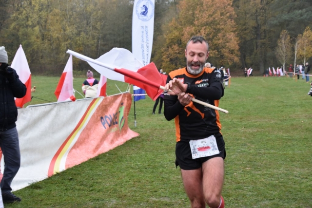 Uczestnik wydarzenia biegnący z flagą Polski