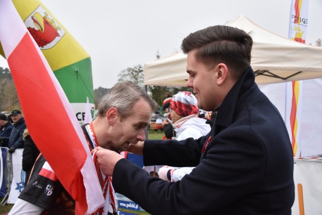 Wicestarosta Policki nakłada uczestnikowi medal za ukończenie biegu