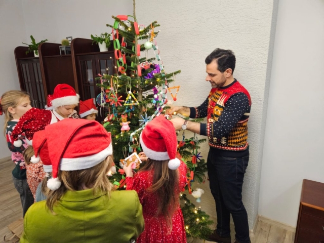 Dzieci ubierają choinkę ze Starostą Polickim