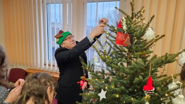 Przewodniczący Rady Powiatu w Policach wraz z młodzieżą wiesza ozdoby na choince